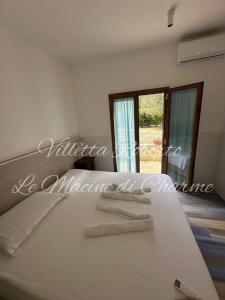 a bedroom with a white bed with a mirror at Villetta Roberto Le Macine di Charme - Pugnochiuso Resort in Vieste