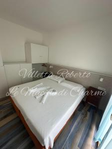 a bed in a room with a sign that reads mother ricochet at Villetta Roberto Le Macine di Charme - Pugnochiuso Resort in Vieste