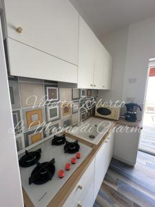 a kitchen with white cabinets and a white counter top at Villetta Roberto Le Macine di Charme - Pugnochiuso Resort in Vieste