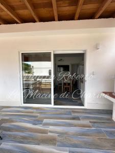 a house with a large glass door to a patio at Villetta Roberto Le Macine di Charme - Pugnochiuso Resort in Vieste