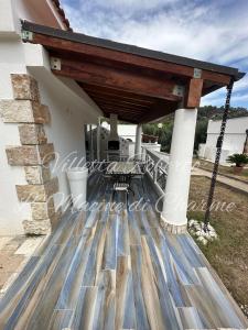a patio with a wooden roof on a house at Villetta Roberto Le Macine di Charme - Pugnochiuso Resort in Vieste