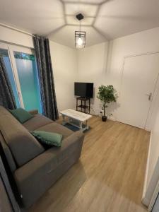 a living room with a couch and a television at Pied à terre au coeur des écuries in Paley