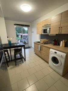 a kitchen with a washing machine and a table with a dining room at Pied à terre au coeur des écuries in Paley