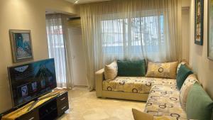 Una sala de estar con un sofá y un televisor de pantalla plana. en Appartement spacieux et jovial au centre de Casablanca, en Casablanca