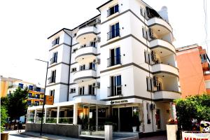 un edificio bianco con finestre nere su una strada di Star Hotel & Restaurant a Golem