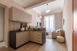 a kitchen with white cabinets and a living room at Le perle del capo in Palermo