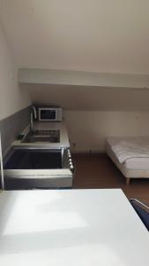 a kitchen with a stove and a bed in a room at Studio Pour Une deux Personnes in La Courneuve