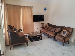 a living room with two couches and a tv at Villa Ahmed Youssef in King Mariout