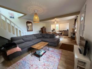 ein Wohnzimmer mit Sofa und Tisch in der Unterkunft Maison charmante à Bec-de-Mortagne avec jardin clôturé in Bec-de-Mortagne