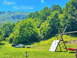 a playground with a slide on a grass field at Kuca Lula Stara planina in Pirot