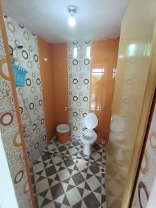 ein Bad mit einem WC und einem schwarz-weißen Fliesenboden in der Unterkunft AAL Homestay in Sabang
