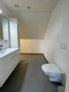 a white bathroom with a toilet and a sink at House with 5 bedrooms, 2 bathrooms, available for ONSS in Stavanger +11 photos