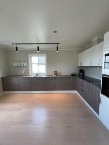 a large kitchen with wooden cabinets and a counter top at House with 5 bedrooms, 2 bathrooms, available for ONSS in Stavanger