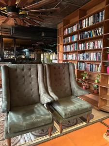 a library with a leather chair and bookshelves at Clarion Bella Casa at Airport in Jaipur