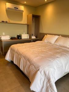 a large white bed in a room with a microwave at Studio 311 BobZ Concept in Barrinha
