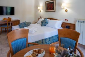 a hotel room with a bed and a table with a plate of food at Hotel Bisanzio Resort in Rossano