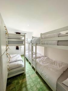 two bunk beds in a room with white walls at Taouarguit Guest House in Imsouane