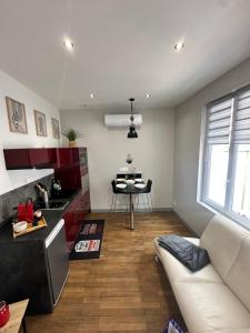 un salon avec un canapé blanc et une cuisine dans l'établissement Le cosy charmeur Climatisé avec patio, à Tours 18 autres photos