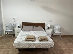 a bedroom with a bed with two chairs and two lamps at Casa MARISA in Águilas