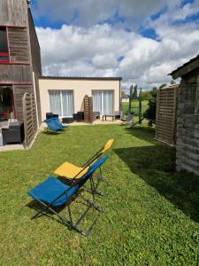 ein Liegestuhl und ein Stuhl auf dem Gras in der Unterkunft Gîte studio 2 pers Le Coquelicot entre Loire et Sologne in Saint-Claude-de-Diray