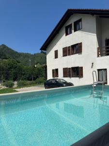 a villa with a swimming pool in front of a house at Pensiunea Valea Pinului in Rau Sadului