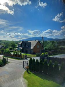 Zubrzyca DolnaZubrzycki Zakątek的一个带栅栏和车道的房子