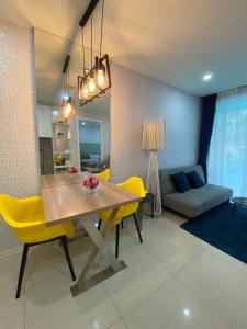 a dining room with a table and yellow chairs at Atlantis pattaya by ramita in Jomtien Beach