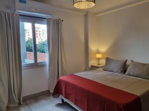 Un dormitorio con una cama grande y una ventana. en Balcarce Confort Apart 1C, en Salta