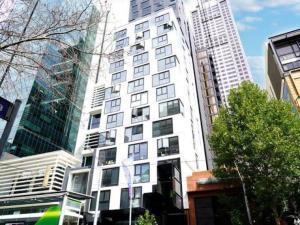 a tall white building in a city with tall buildings at City Central 2BR Retreat on Chinatown Bourke Street in Melbourne