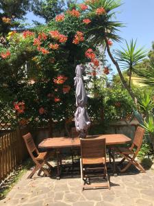 a wooden table with chairs and an umbrella on it at Il Pettirosso in Acciaroli