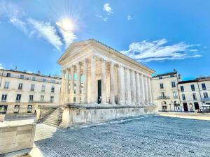 a building with columns in front of a building at Au cœur du centre historique - Immeuble classé - Terrasse - climatisé in Nîmes