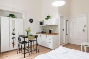 a white kitchen with a table and chairs in a room at Main Square Apartments - U Mamlasů in Brno