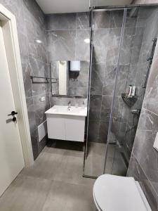 a bathroom with a shower and a sink and a toilet at SanPietro Relax Apartment in Durrës