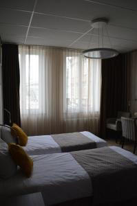 una camera d'albergo con due letti e una finestra di Hotel Mille Colonnes a Lovanio