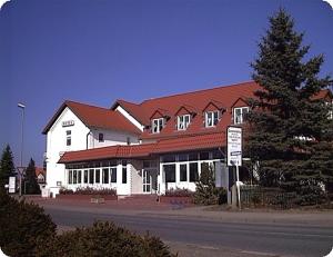 ein großes weißes Gebäude mit rotem Dach in der Unterkunft Hotel Kiebitz an der Ostsee in Börgerende-Rethwisch