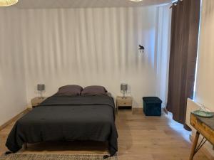 una camera da letto con un letto con due comodini e due lampade di Chez Cornélia a Estaing