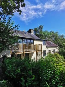 a house with a deck on the side of it at Plasbach Cottage in Llandeilo