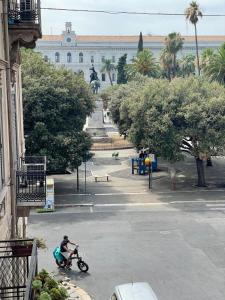 Un uomo che va in bicicletta davanti a un palazzo di Isvi Bari Comfort Rooms a Bari