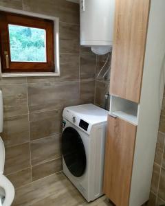 a washing machine in a small bathroom with a window at Apartment Sidro in Posedarje