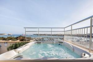 a hot tub on a balcony with a view of the ocean at Seagull Penthouse Marsaxlokk in Marsaxlokk