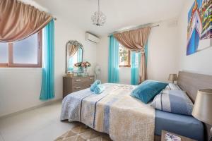 a bedroom with a bed with a blue teddy bear on it at Seagull Penthouse Marsaxlokk in Marsaxlokk