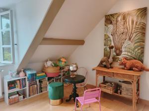 a attic room with a desk with toys on it at Suite familiale "Le Logis des Ptits Lynx" in Montain