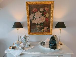 a table with two lamps and a painting on the wall at Suite familiale "Le Logis des Ptits Lynx" in Montain