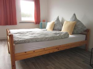 a wooden bed with pillows on it in a bedroom at Hildebrandts Ferienwohnung in Neu Darchau