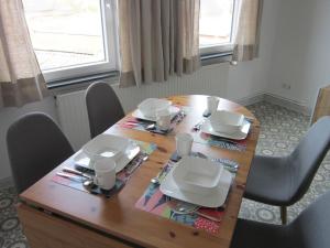 a dining room table with chairs and a wooden table with plates at Hildebrandts Ferienwohnung in Neu Darchau