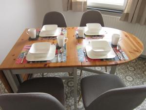 a wooden table with chairs and plates and cups on it at Hildebrandts Ferienwohnung in Neu Darchau