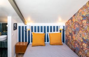 a bedroom with a large bed with yellow pillows at Les Camuches de la Coopérative in Tournai