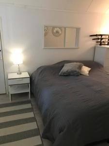 a bedroom with a bed and a table with a lamp at Villa Mäntyrinne in Valkeakoski