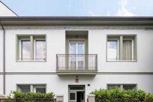 a white building with a balcony on it at Maison Bordoré in Faenza