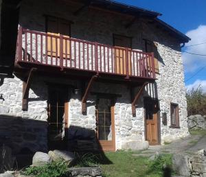 a stone house with a balcony on top of it at Les maisons d'Ustou. in Ustou